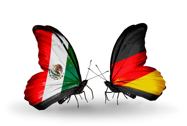 Dwa motyle z flag Niemiec i Meksyku na skrzydłach — Zdjęcie stockowe