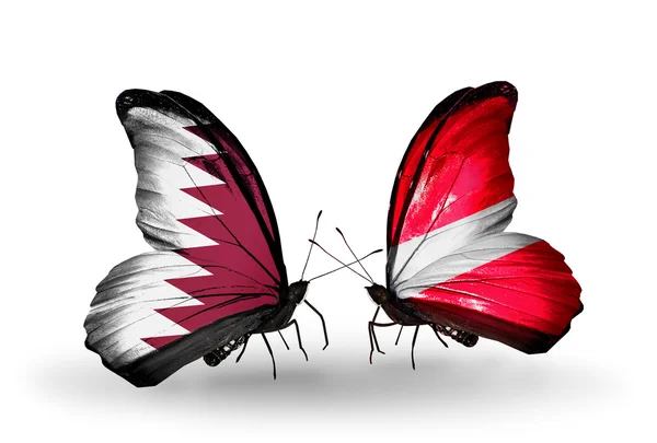 Papillons avec drapeaux Qatar et Lettonie sur les ailes — Photo