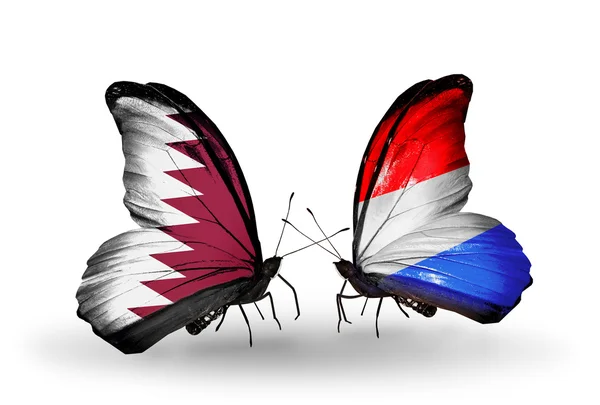 Schmetterlinge mit kataranischen und luxemburgischen Flaggen auf Flügeln — Stockfoto