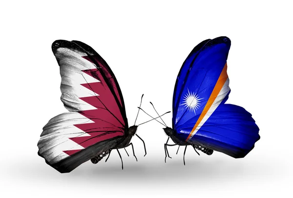 Vlinders met qatar en Marshalleilanden vlaggen op vleugels — Stockfoto