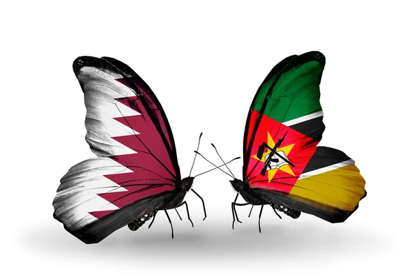 Mariposas con banderas de Qatar y Mozambique en alas — Foto de Stock