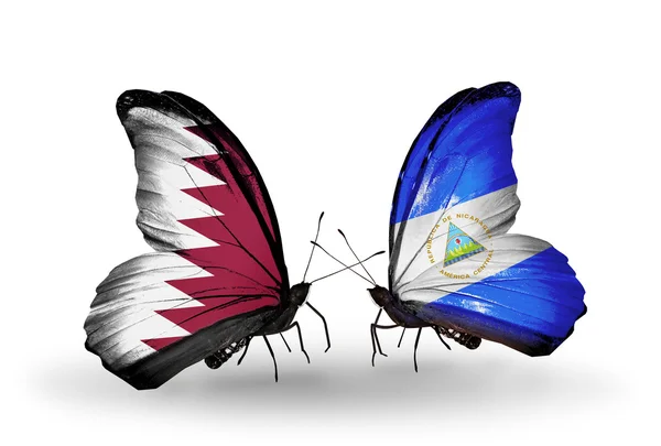 Borboletas com bandeiras do Qatar e Nicarágua em asas — Fotografia de Stock