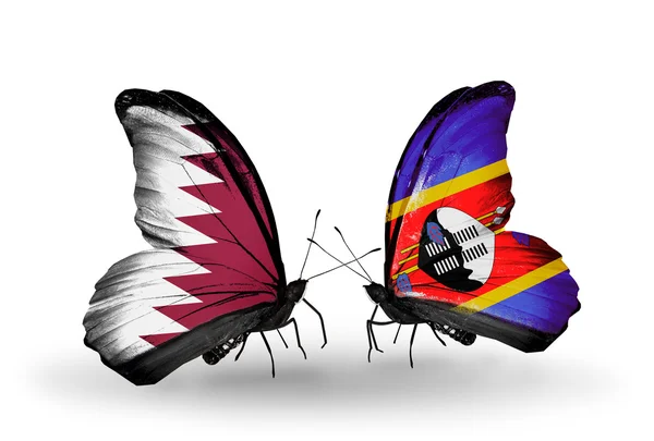 Vlinders met qatar en swaziland vlaggen op vleugels — Stockfoto