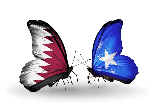 Mariposas con qatar y somalia banderas en las alas — Stockfoto