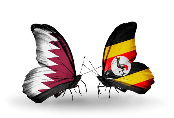 Vlinders met qatar en Oeganda vlaggen op vleugels — Stockfoto