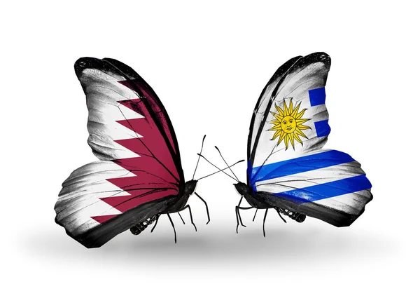 Butterflies with Qatar and Uruguay flags on wings — Stock Photo, Image