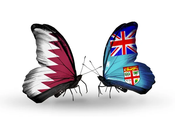 Vlinders met qatar en fiji vlaggen op vleugels — Stockfoto