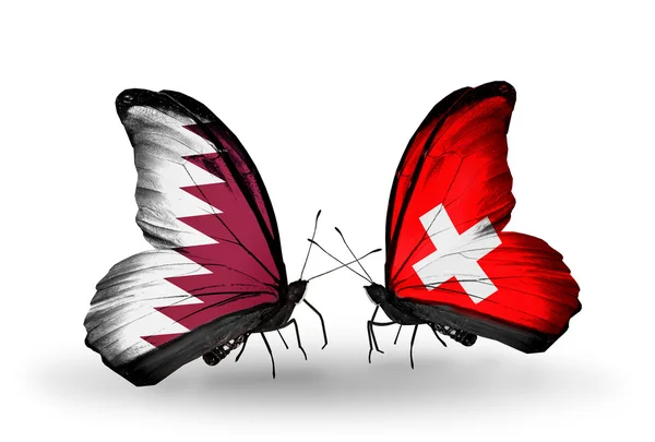 Vlinders met qatar en Zwitserland vlaggen op vleugels — Stockfoto