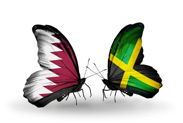 Vlinders met qatar en jamaica vlaggen op vleugels — Stockfoto