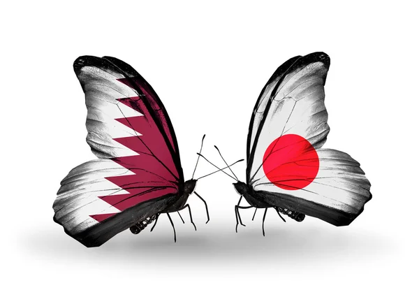 Vlinders met qatar en japan vlaggen op vleugels — Stockfoto