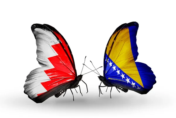 Schmetterlinge mit Bahrain und Bosnien-Herzegowina-Flaggen auf Flügeln — Stockfoto