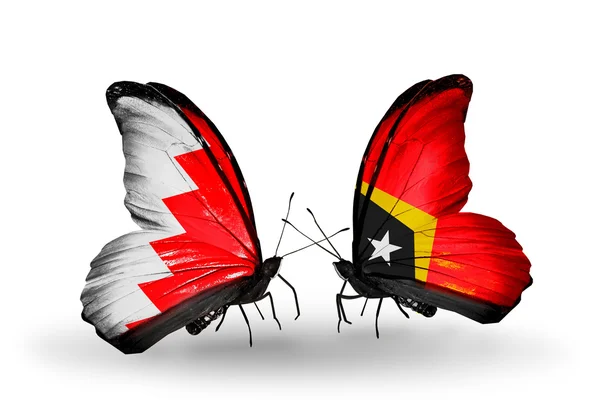Schmetterlinge mit Bahrain und Osttimor-Fahnen auf Flügeln — Stockfoto