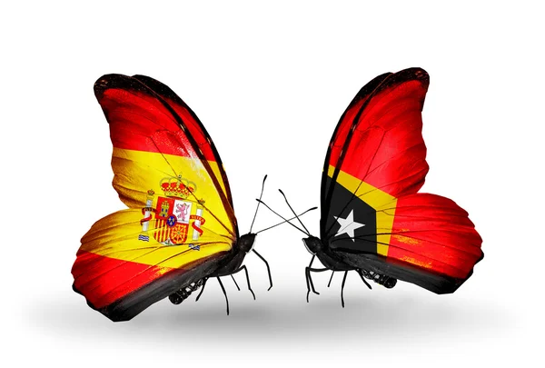 Mariposas con banderas de España y Timor Oriental en alas — Foto de Stock