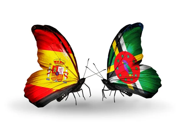 Farfalle con bandiere Spagna e Dominica sulle ali — Foto Stock
