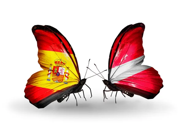 Butterflies with Spain and Latvia flags on wings — Stock Photo, Image