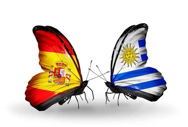 Borboletas com bandeiras de Espanha e Uruguai em asas — Fotografia de Stock