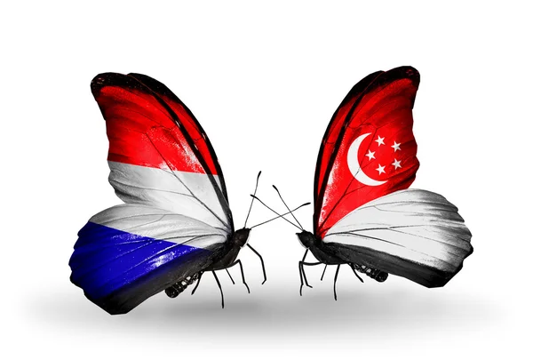 Πεταλούδες με την Ολλανδία και τη Σιγκαπούρη σημαίες με φτερά — Φωτογραφία Αρχείου