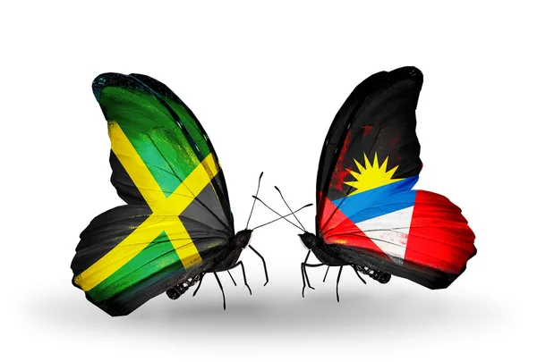 Farfalle con bandiere giamaicane e antigua e barbuda sulle ali — Foto Stock