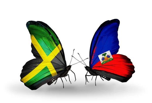 Borboletas com bandeiras da Jamaica e Haiti em asas — Fotografia de Stock
