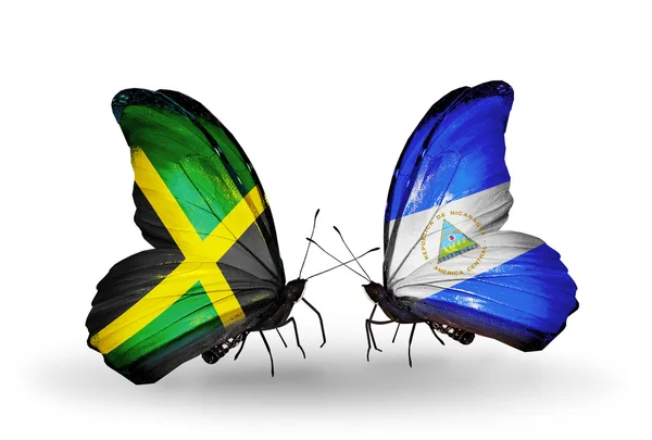 Vlinders met jamaica en nicaragua vlaggen op vleugels — Stockfoto