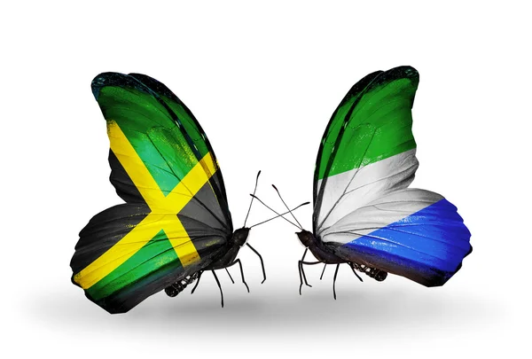 Vlinders met jamaica en sierra leone vlaggen op vleugels — Stockfoto