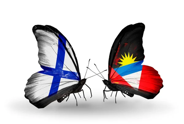 Mariposas con banderas de Finlandia y Antigua y Barbuda en alas — Foto de Stock