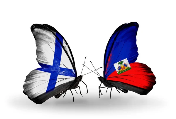 Schmetterlinge mit finnischen und haiti-Flaggen auf Flügeln — Stockfoto