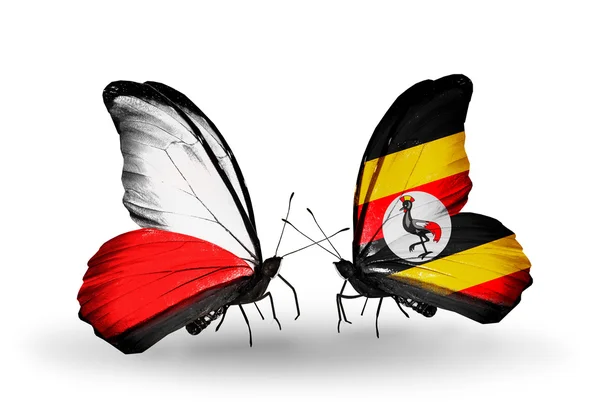 Dva motýli s vlajkami Polska a Ugandy — Stock fotografie