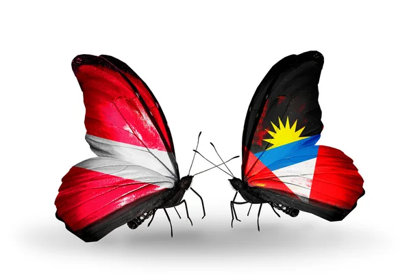 ラトビア、アンティグア ・ バーブーダの国旗と 2 匹の蝶 — ストック写真