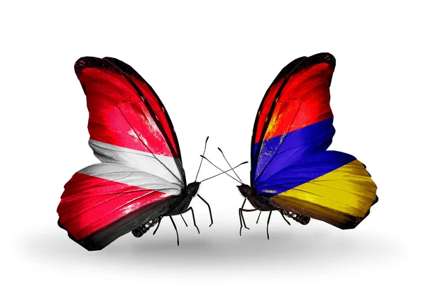 Две бабочки с флагами Латвии и Армении — стоковое фото