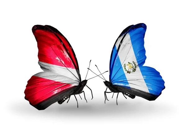 Две бабочки с флагами Латвии и Гватемалы — стоковое фото
