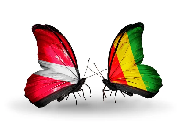 Two butterflies with flags of  Latvia and Guinea — Stock Photo, Image