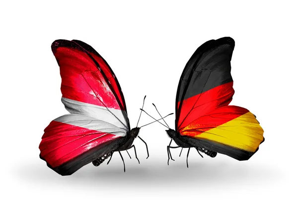 ラトビアそしてドイツの国旗を持つ 2 つの蝶 — ストック写真