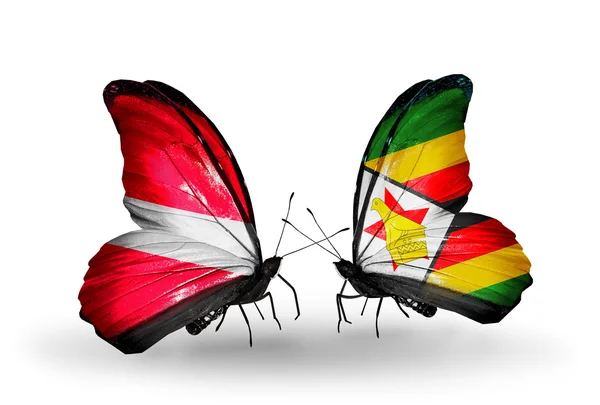 Deux papillons avec des drapeaux de la Lettonie et du Zimbabwe — Photo