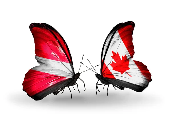 Letonya ve Kanada bayrakları taşıyan iki kelebek — Stok fotoğraf