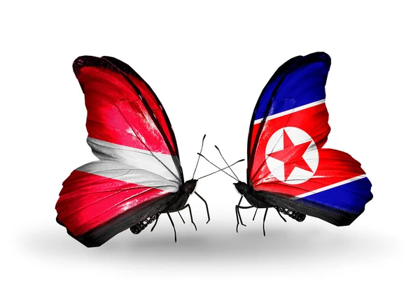 Две бабочки с флагами Латвии и Северной Кореи — стоковое фото
