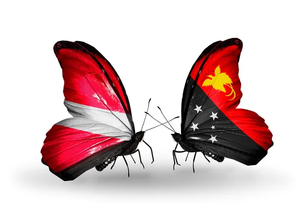 Бабочки с флагами Латвии и Папуа - Новой Гвинеи — стоковое фото