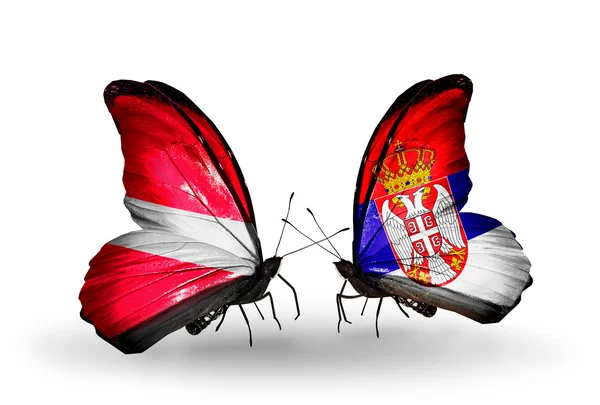Бабочки с флагами Латвии и Сербии — стоковое фото