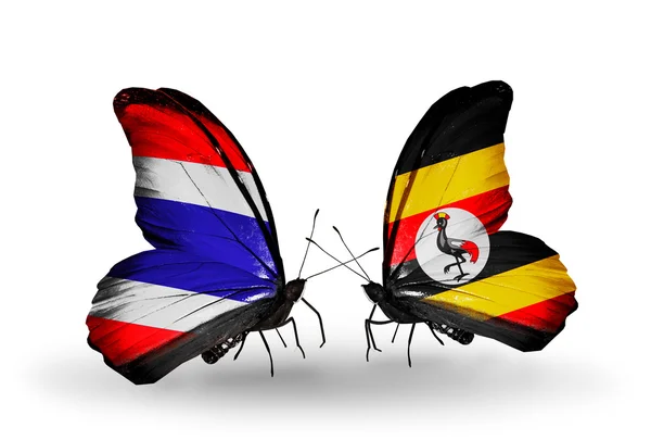 Farfalle con bandiere sulle ali della Thailandia e dell'Uganda — Foto Stock