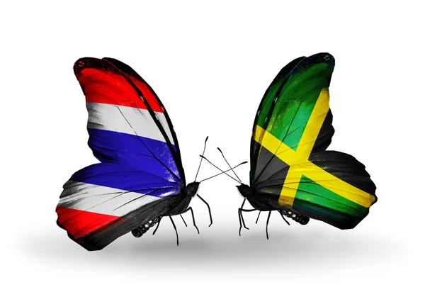 Motýli s Thajskem a Jamajka vlajky na křídlech — Stock fotografie