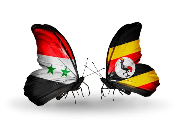 Kelebekler kanat uganda ve Suriye bayrakları ile — Stok fotoğraf