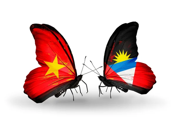 Farfalle con bandiere Vietnam e Antigua e Barbuda sulle ali — Foto Stock