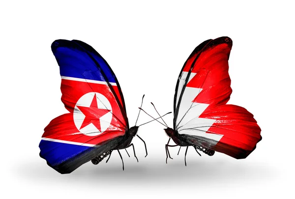 Vlinders met Noord-korea en Bahrein vlaggen op vleugels — Stockfoto
