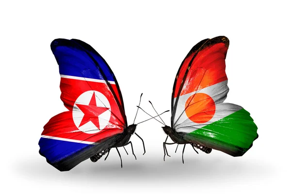 Kuzey Kore ve Nijer bayrakları kanatlar üzerinde kelebekler — Stok fotoğraf