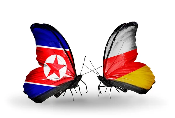 Borboletas com bandeiras da Coreia do Norte e da Ossétia do Sul em asas — Fotografia de Stock