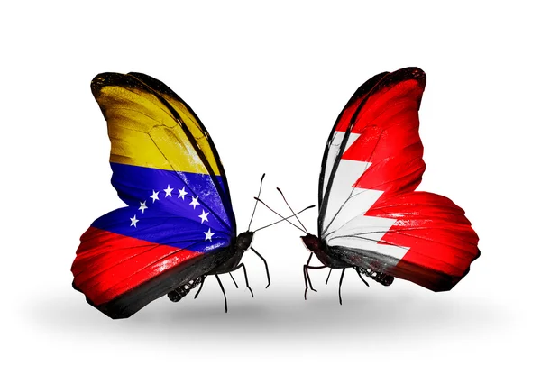 Schmetterlinge mit Venezuela und Bahrain-Flaggen auf Flügeln — Stockfoto