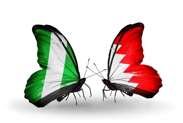 Schmetterlinge mit Nigeria und Bahrain-Flaggen auf Flügeln — Stockfoto