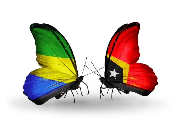 Borboletas com bandeiras do Gabão e Timor-Leste em asas — Fotografia de Stock