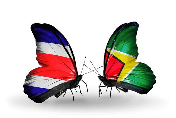 Kosta Rika ve guyana bayrakları kanatlar üzerinde kelebekler — Stok fotoğraf