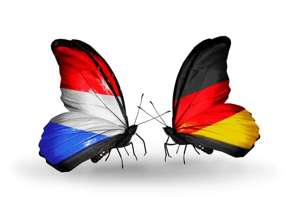 Farfalle con bandiera lussemburghese e tedesca sulle ali — Foto Stock